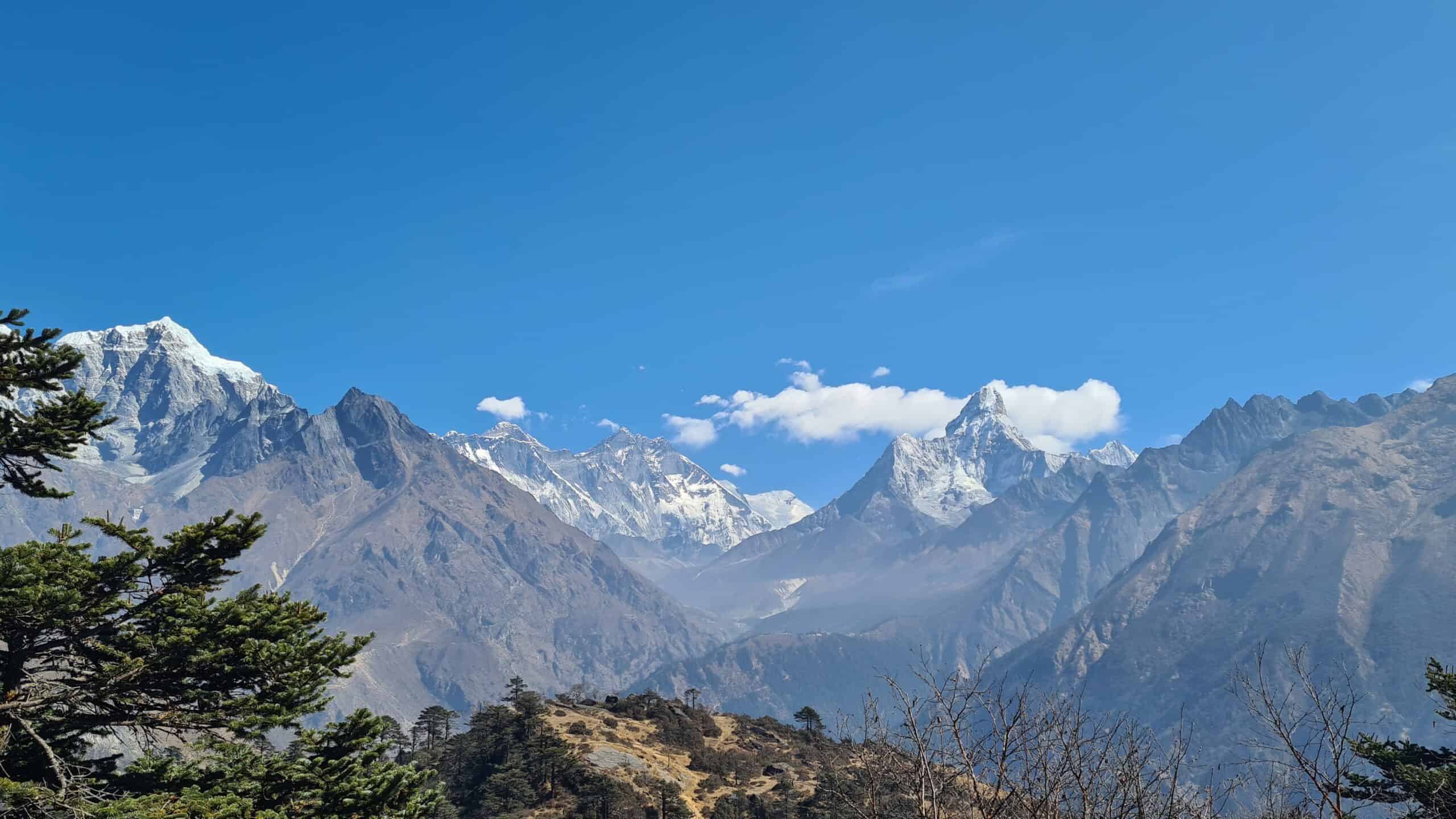 A kids stood looking away at massive snow capped mountains. A bucket list view on a family gap year.