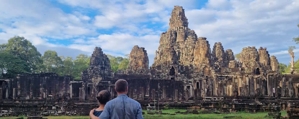 A family looking away at a large temple complex popular with tourists.