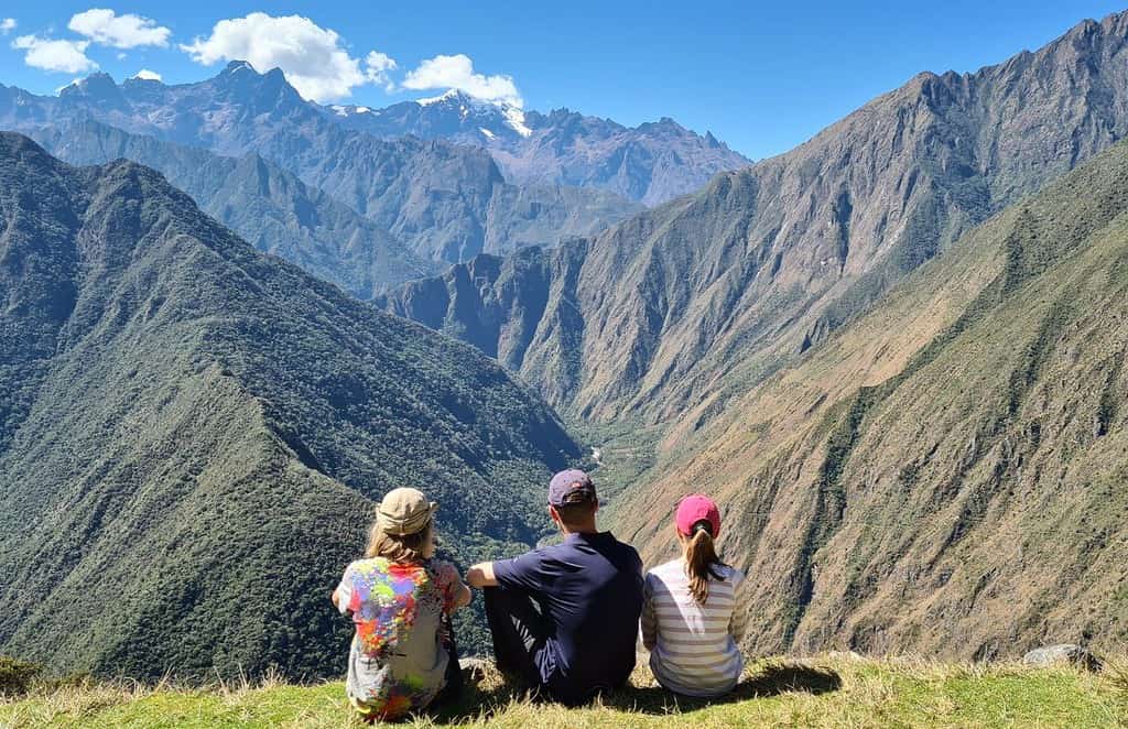 A family admiring a view over mountains on the Inca Trail in Peru with kids. Peru is a bucket list destination for families travelling for cultural experiences and adventure.