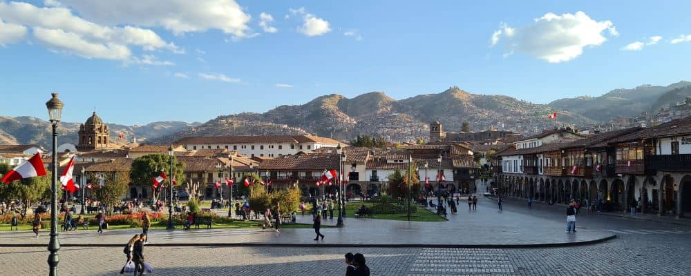 The centre of Cusco with national flags and mountains. 