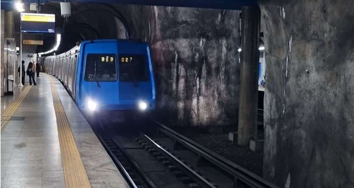 Blue Subway Train coming into a station in Brazil with people stood on the platform. Perfect for getting around Brazil with Kids