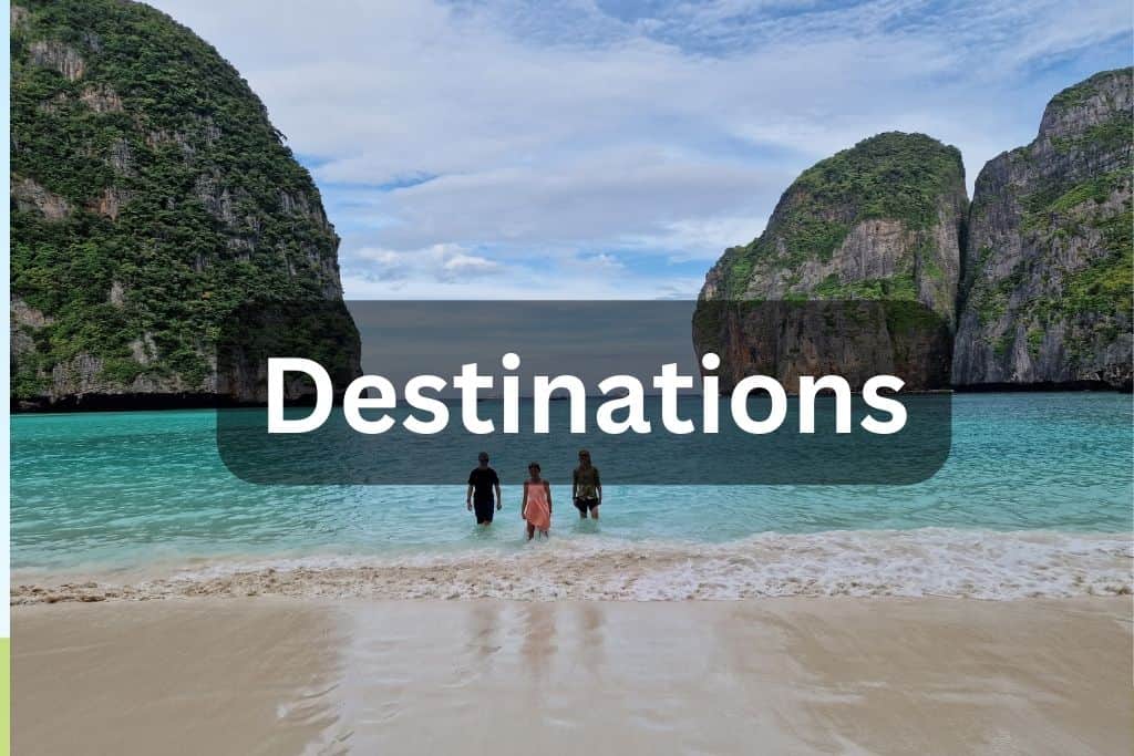 Travel family stood in water at Maya Bay, a rocky destination in Thailand