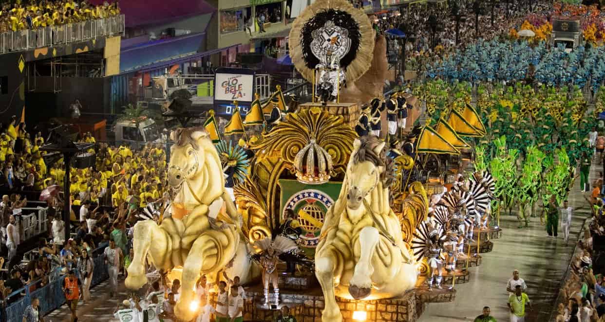 A parade with massive horses leading colourful people along the road. Rio Carnival brings the streets of Rio-De-Janerio alive