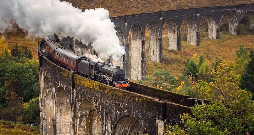 A view from a family hike of a steam train crossing Glenfinnan Viaduct in Scotland.