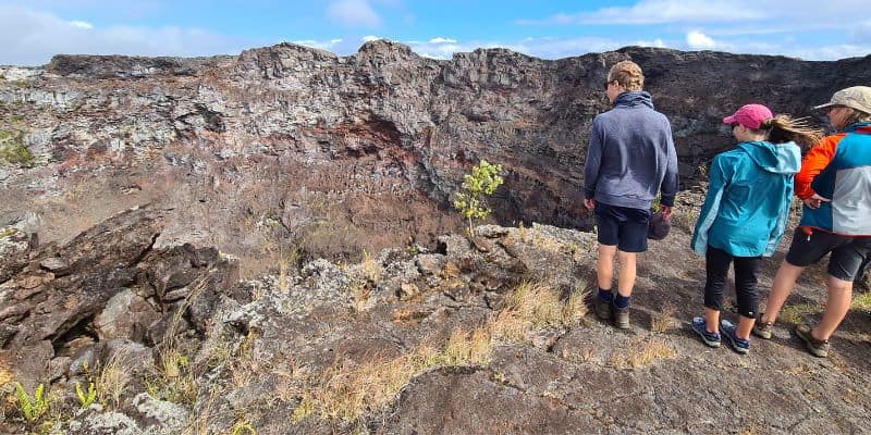 3 kids stood looking into a volcanic crater rim on an ideal road trip