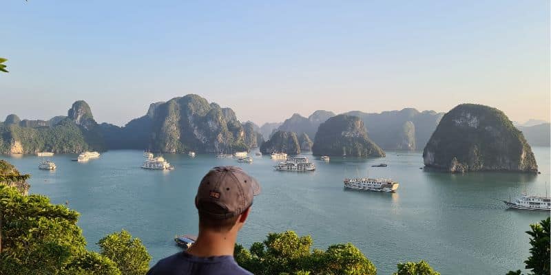 A child looking out over water with boats - Ha Long Bay, Vietnam