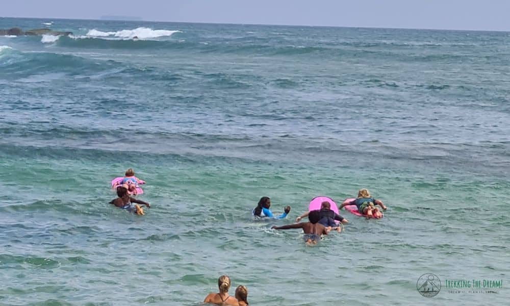 Kids on surf boards heading out to sea for a lesson in Sri Lanka.