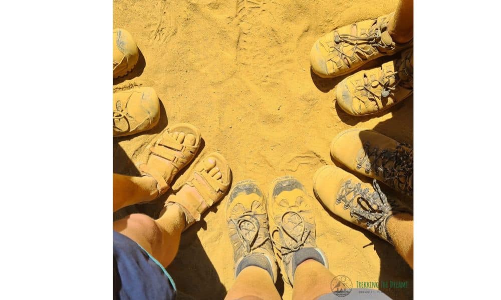 A family of five stood in a circle covered in orange sand. 