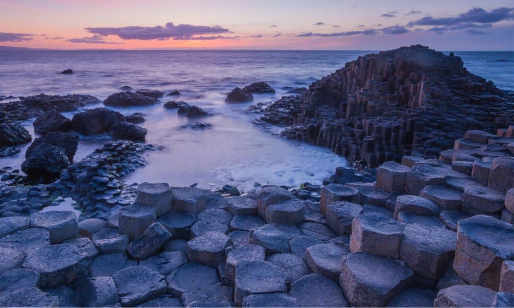 The sea splashing over hexagonal rock formations at Giant's Causeway 