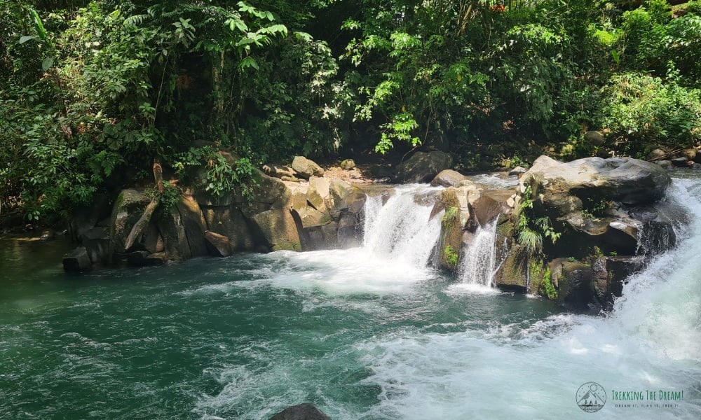 Flowing waterfalls over rocks in a green rainforest during wet season in Costa Rica