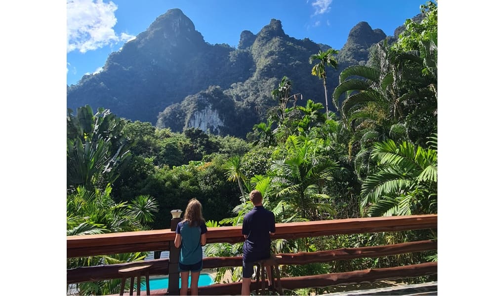 Kids over looking towering cliffs and jungle in Thailand