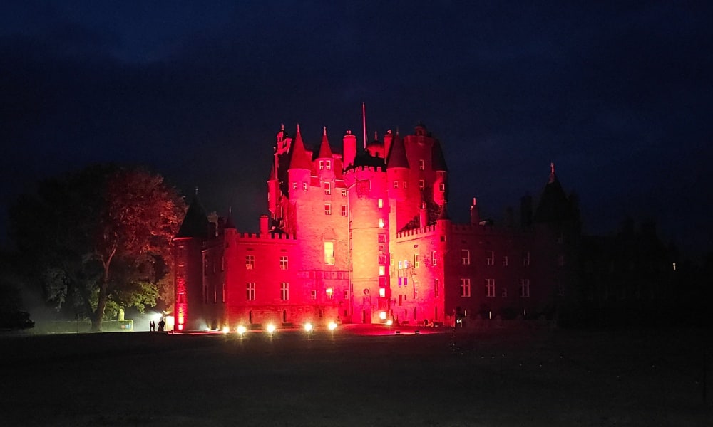 A castle lit up red at night