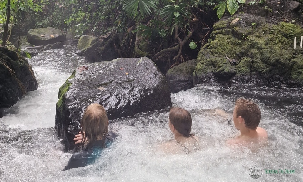 kids sat in water in a hot spring