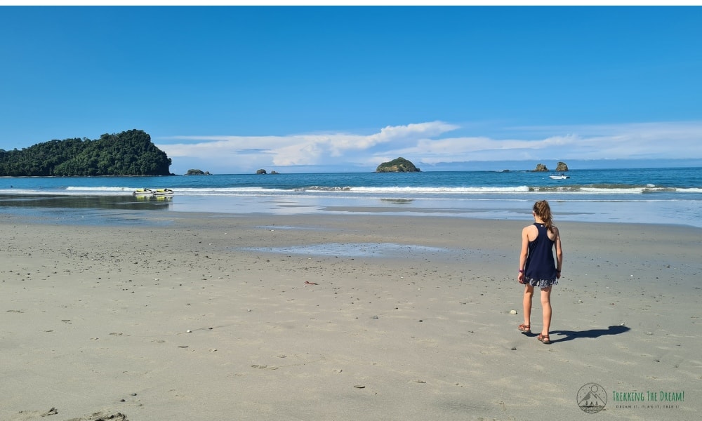 A kid walking on a beach with rock formations in Costa Rica