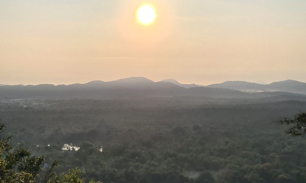 Bright sun central over Green jungle and mountains. Viewpoint from Pidurangala Rock 