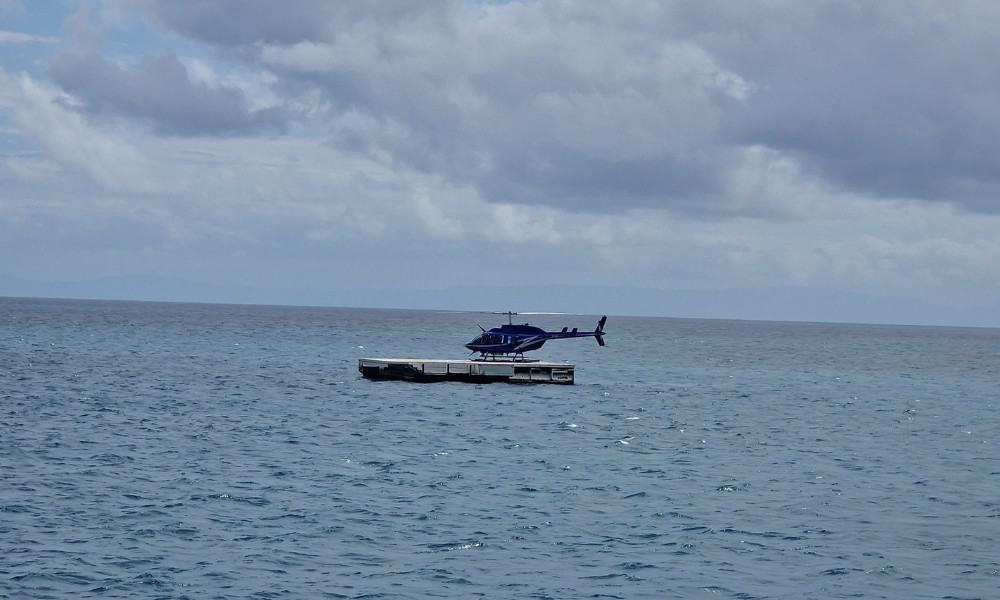 A helicopter landing on a platform in the middle of the sea. This is a bucklist experience that is worth it as the Great