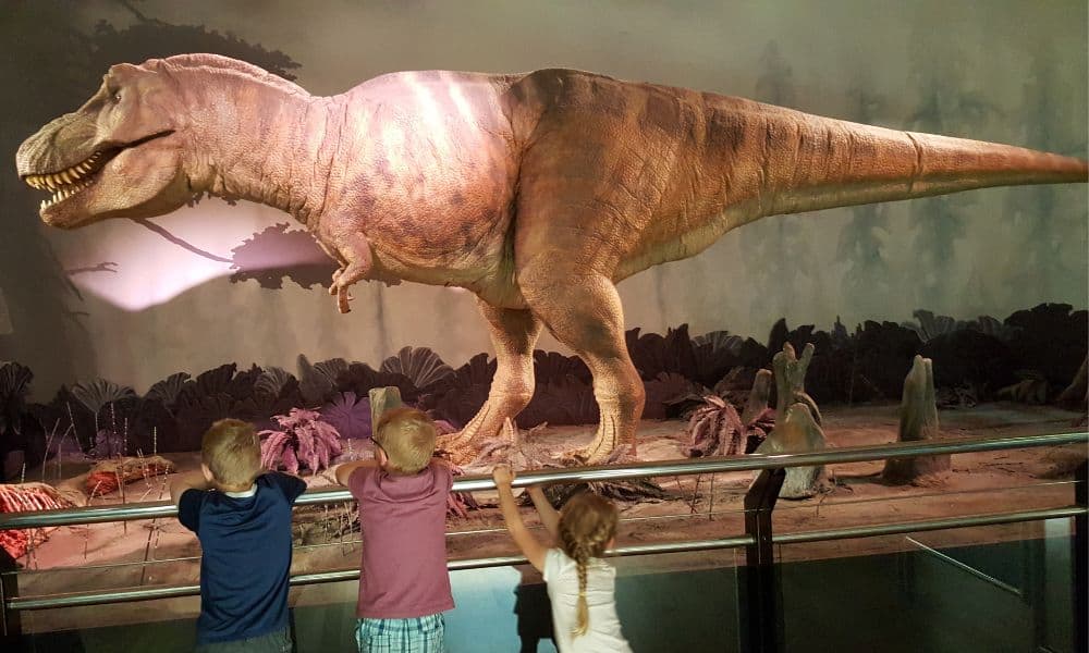 Lifesize dinosaur on display with Trekking The Dream kids visiting a London museum.