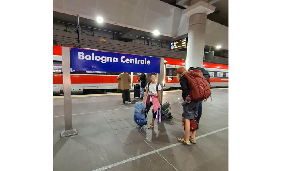 Trekking The Dream Family backpacking by train at Bologna train station in Italy. Good transport is a reason to visit Italy.