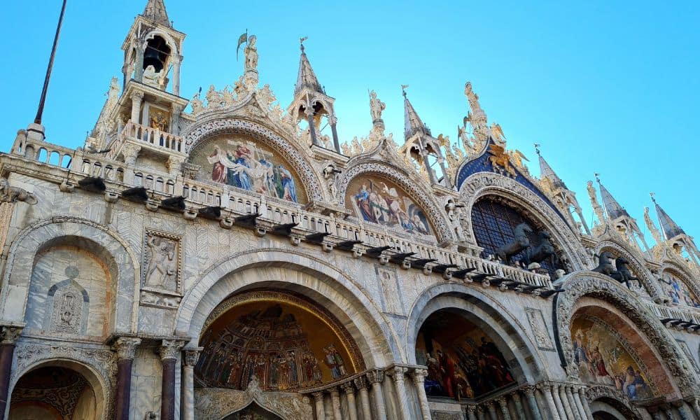 Ornate building with arches and spires against a blue sky. This is a building in Venice Italy.