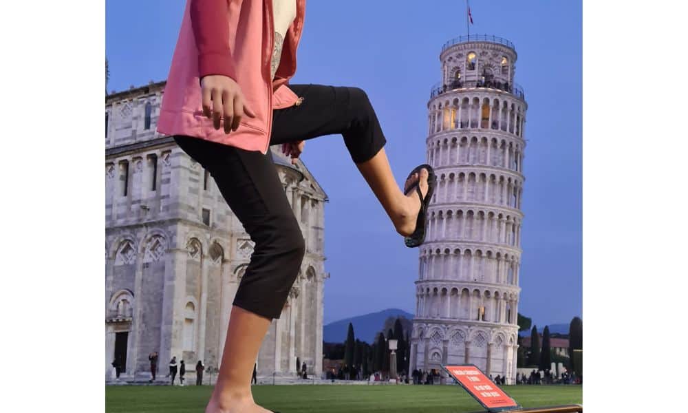 A kid kicking over a tall building that is not standing straight. The Leaning Tower of Pisa is a great reason to visit Italy with kids.