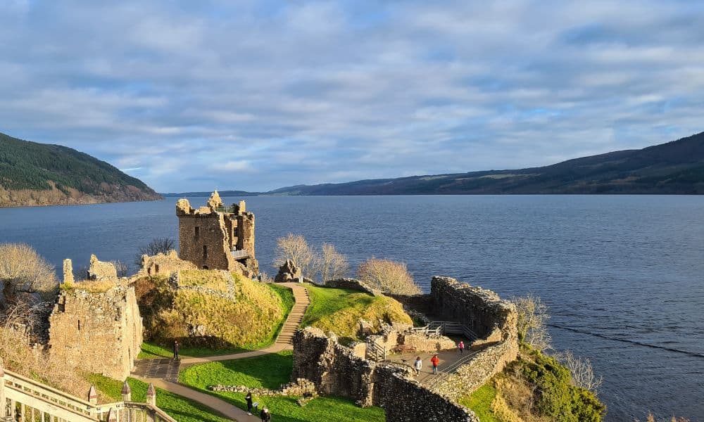 Castle ruins surrounded by a large body of fresh water and distant hills. This is a great addition to a summer Scottish itinerary with kids.