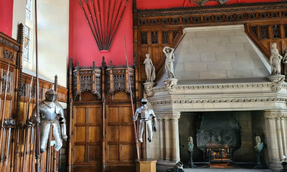 Large wooden and red medieval hall with  metal knight suits and a fireplace in Edinburgh Castle.  