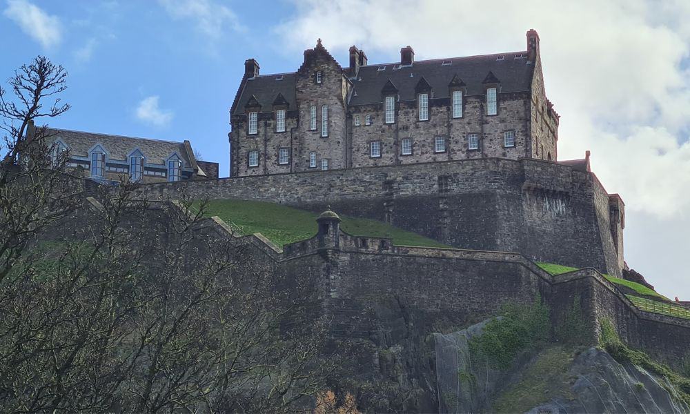 Castle on a rock with surrounding walls. Edinburgh Castle is a must visit attraction.