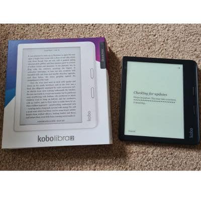 A black E-reader next to a Kobo packaging box that has a picture of a white kobo.