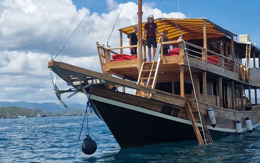 Wooden sail boat in the sea with Trekking The Dream Family on board ready for a Komodo Island Tour.