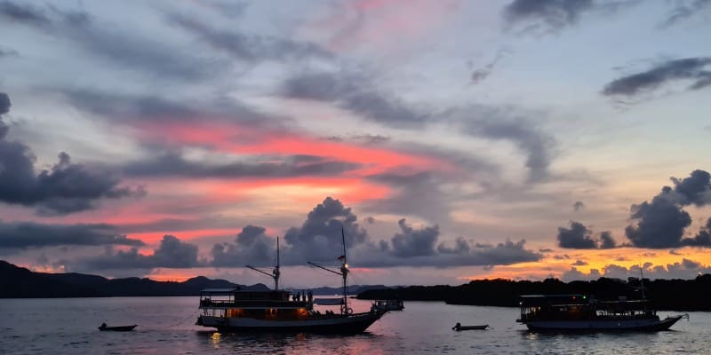 Boats at sea as the sun sets in Indonesia at part of a tour.