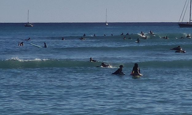 People surfing the the ocean at Waikiki Beach.