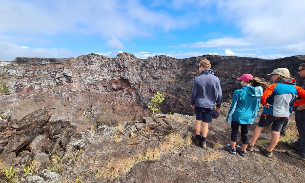 Family looking into a crater. A popular thing to do at Hawaii's Volcano National Park with kids.