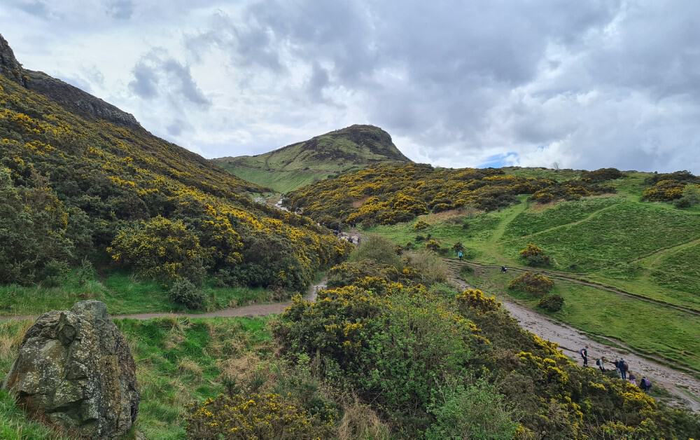 Grassy hills with hiking trails to the rocky summit. One of the best hikes in Edinburgh is to Arthur's Seat.