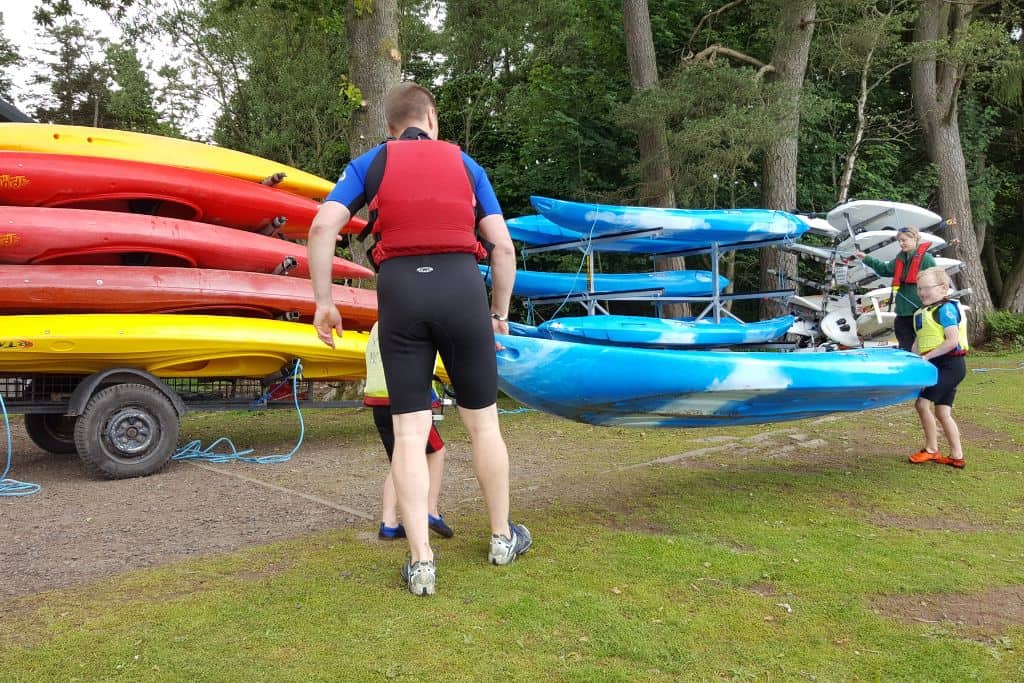 Family working together to put away kayaks.