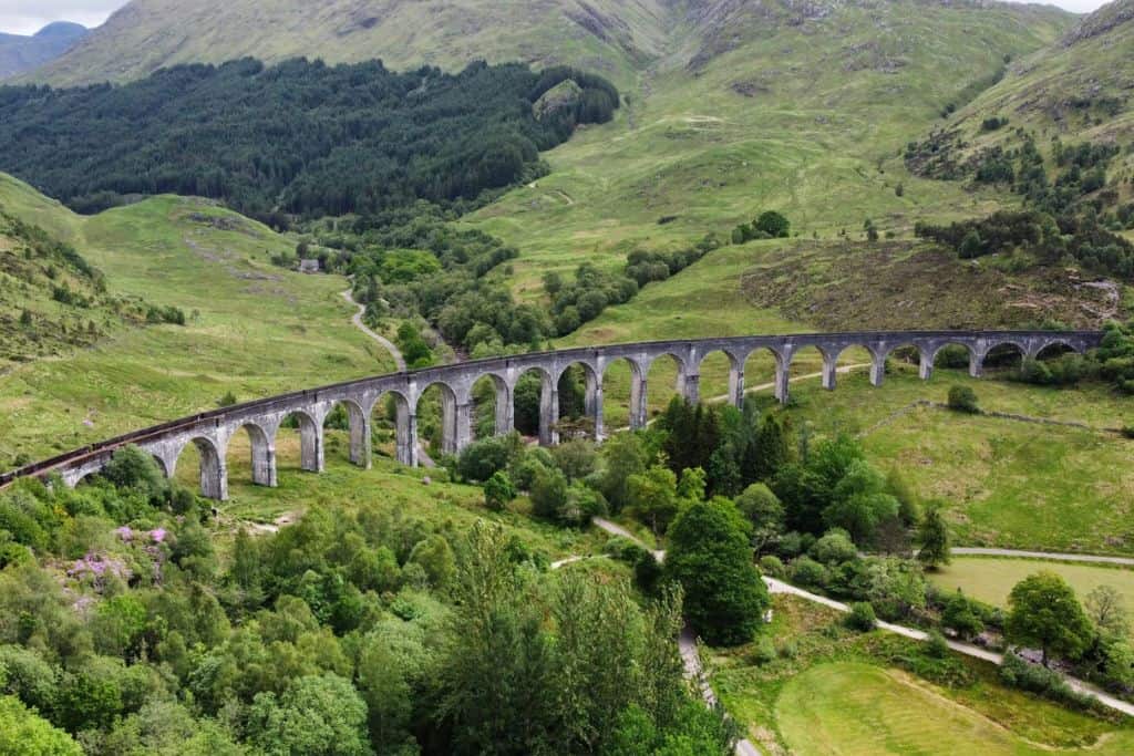 Long arched stone viaduct is green hill setting in Scotland.