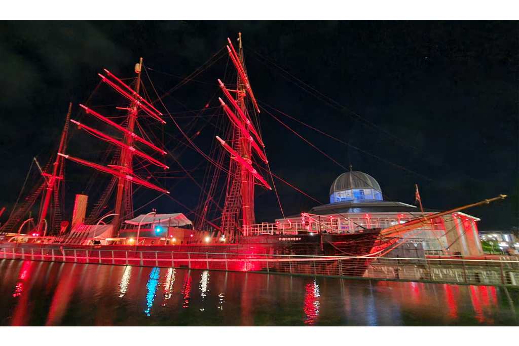 Boat lit up red at night. Discovery Point, Dundee