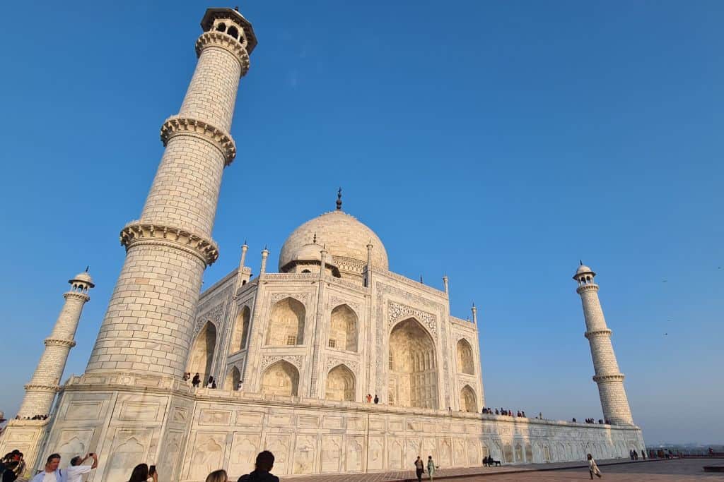 Large white marble building against blue sky in India.