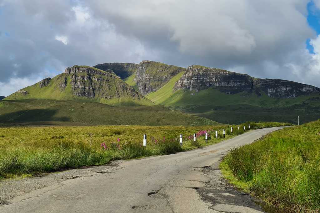 Road leading towards green mountains in Scotland.