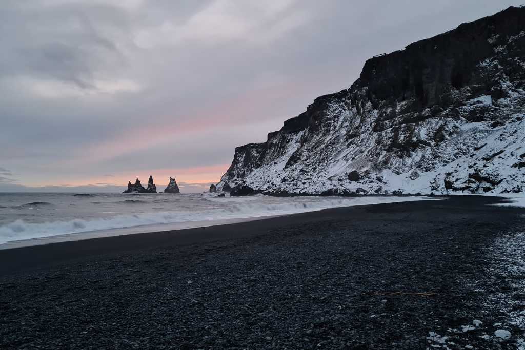 Black Sand Beach with rock stacks in the sea. A budget friendly thing to do in Iceland.