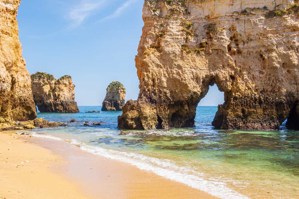 Sunny beach with rocks in the sea in winter in Europe.