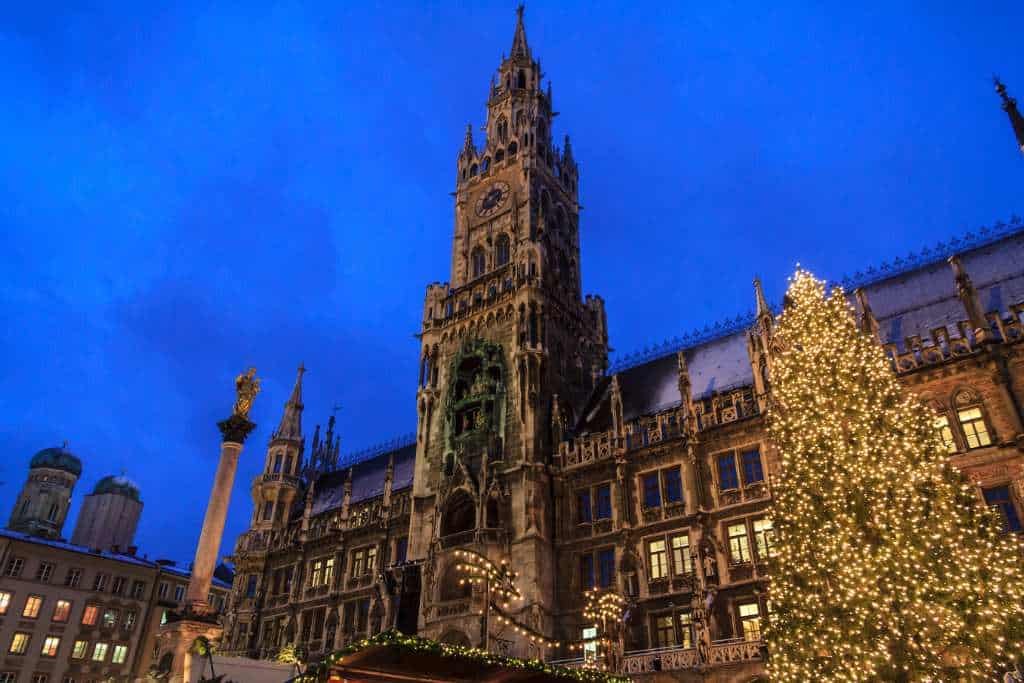 A grand church and chrsitmas tree lit up at winter.