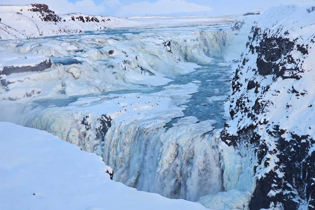 Large frozen waterfall covered in snow