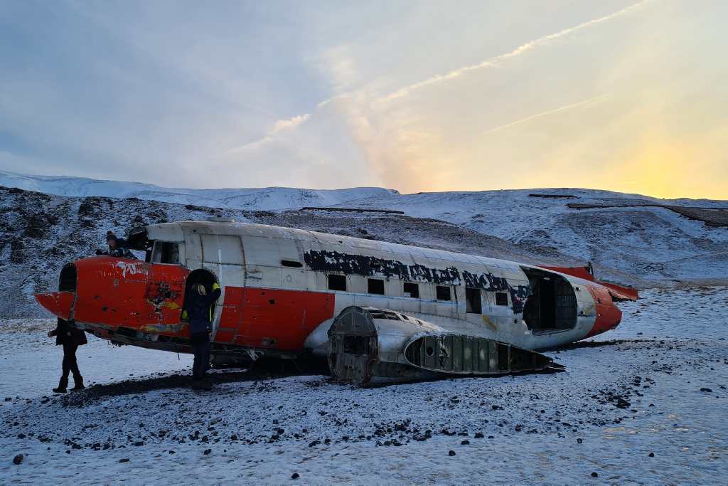 Children playing on a plane wreck in the snow. 