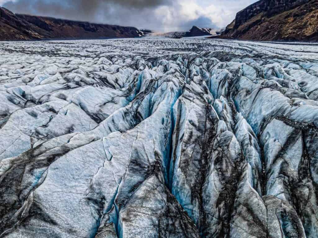 White, blue and grey folded ice on a glacier.