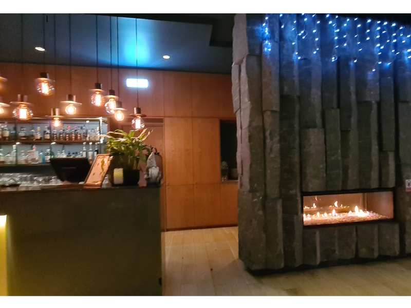 Hotel foyer lit up with lights and a fire as a welcome in Iceland