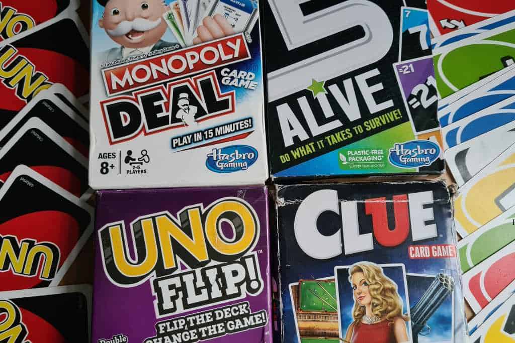 A selection of boxed family travel card games and scattered uno cards.