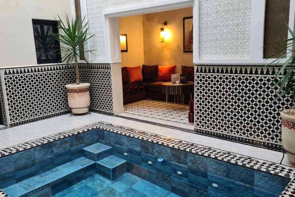 A plunge pool and seating inside a traditional Moroccan riad in Marrakesh.