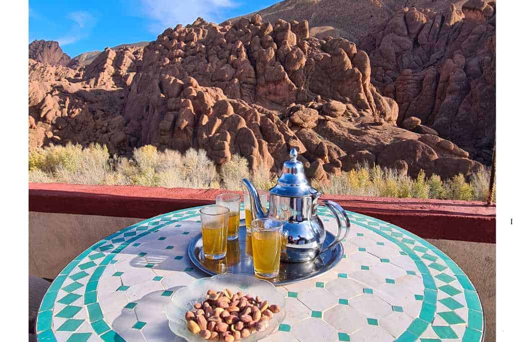 Table with tea and nuts in front of a large rock resembling Monkey paws in Dades Gorge Morocco.