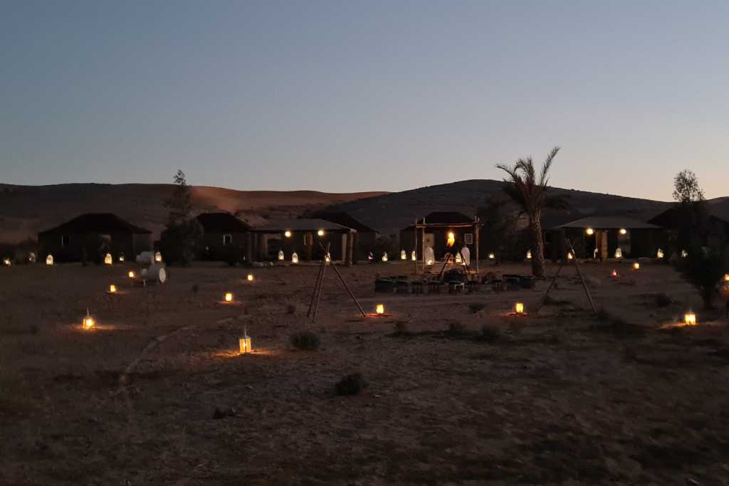 candles lighting up tents in a camp in the desert at dusk in the Sahara Morocco. 