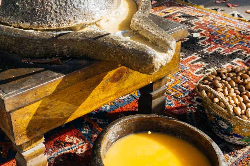 Oil being handmade ground from nuts into a bowl.